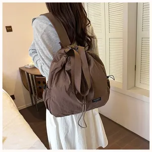 Vista dettagliata dello zaino in nylon marrone impermeabile con coulisse indossato