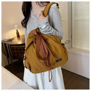 Donna con borsa in nylon impermeabile giallo senape con coulisse in un interno accogliente