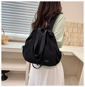 Vista posteriore di uno zaino nero in nylon con coulisse indossato da una modella