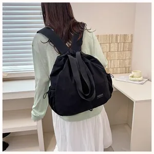 Vista posteriore di uno zaino in nylon nero con coulisse indossato da una modella