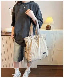 Primo piano di una versatile borsa tote in nylon beige con coulisse per fitness e yoga