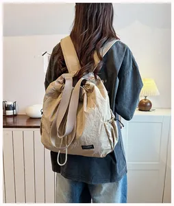 Vista posteriore di una donna con zaino in nylon kaki con coulisse in stanza calda