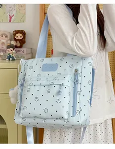 Close-up of a cute light blue star-patterned backpack worn by a teenage model for school.
