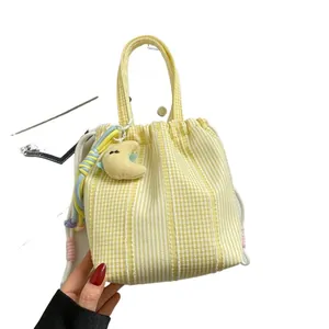 Bolso de cuadros amarillos y blancos con colgante de luna para el transporte diario