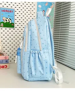 Side view detail of a light blue star patterned student backpack with side pocket