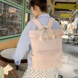 Lightweight pink leisure travel backpack shown in an outdoor cafe setting on a model.