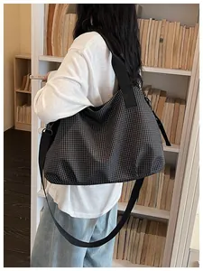 Lifestyle view of a checkered large capacity nylon tote bag worn as a shoulder bag
