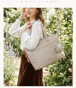 Elegante gesteppte Wickeltasche für Damen, große Reisetasche im Garten-Szenario.