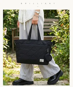 Lifestyle-Aufnahme der großen schwarzen gesteppten Wickeltasche mit Rundetui.