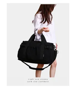 Détail d'un grand sac de sport noir porté par un mannequin pour le voyage et le fitness