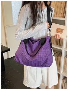 Stylish purple checkered nylon tote bag worn as a crossbody bag in a modern setting