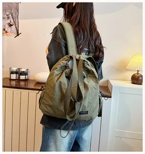 Vista lifestyle di uno zaino con coulisse in nylon verde impermeabile per le donne