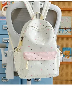 Cute Japanese style backpack with polka dots and lace bow hanging on a white chair.