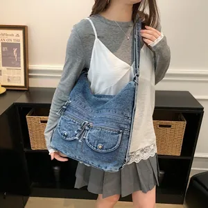 Vintage blue denim tote bag with multiple pockets worn by a model in a casual setting