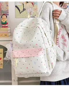 Detailed shot of white polka dot school backpack with lace bow and pink pocket