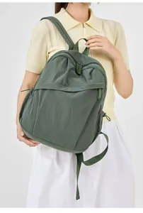 Green nylon backpack for women shown on a model, ideal for daily commute and school