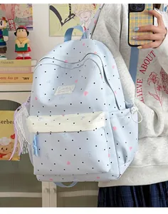 Detailed view of the light blue polka dot backpack with lace bow accessory