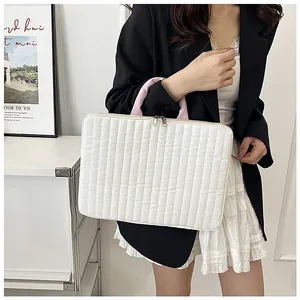 Elegante custodia trapuntata bianca per laptop con manici rosa portata da un modello