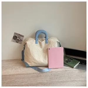 Grande borsa da viaggio a righe mostrata con un tablet rosa per le dimensioni.