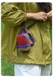 Close-up of a colorful mini nylon storage pouch for coins and earphones in outdoor use.