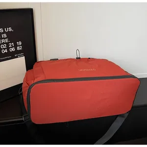 Detailed view of red sports travel bag featuring durable nylon fabric and gold logo