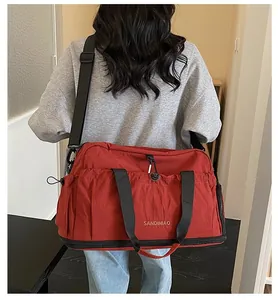 Red large capacity travel bag worn by model for sports gym or short weekend trips