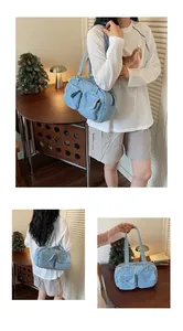 Detailed view of the light blue denim fabric and pocket structure of the bowling bag