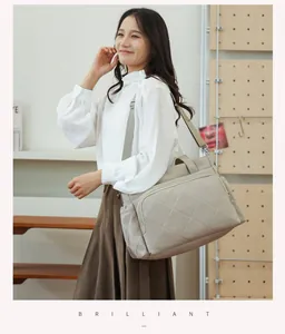 Stylish quilted diaper bag for moms carried by a model in a cozy lifestyle room