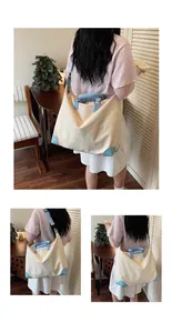 Modella che indossa una grande borsa da viaggio crema e blu in un ambiente accogliente