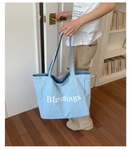 Large light blue nylon tote bag with Blessings print and reversible checkered lining