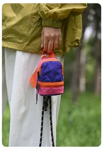 Mini colorful nylon pouch with lanyard for coins and earphones held by hand