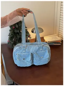 Casual light blue denim Boston bag with front pockets held in a lifestyle setting