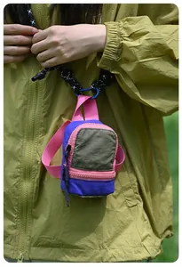 Close-up of vibrant color-block micro-backpack pouch hanging on a braided neck lanyard