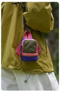 Macro view of a colorful mini storage pouch hanging on a person in an outdoor setting
