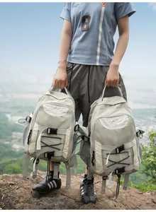 Detailansicht von zwei hellgrünen Wanderrucksäcken, die im Freien gehalten werden.