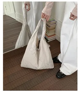 Cream nylon tote bag with flower embroidery shown in a mirror reflection for daily use