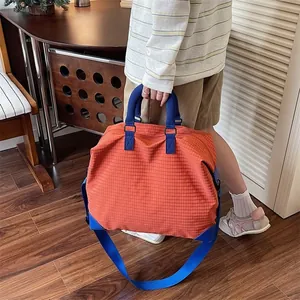 Ampia borsa da viaggio a scacchi arancione con manici blu e comoda tracolla rimovibile