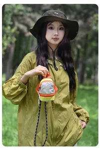 Mini colorful outdoor earphone storage pouch with lanyard held by a model in a park.
