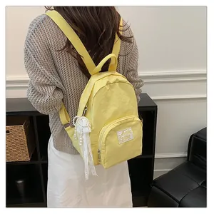 Stylish yellow minimalist casual backpack featuring a decorative white pearl tassel