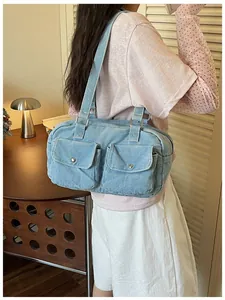 Light blue denim bowling bag with double front pockets shown on female model