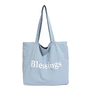 Large capacity light blue nylon shoulder tote bag with white Blessings print text