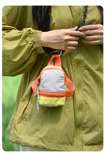 Vibrant dopamine-style mini backpack pouch for earphones and lipstick storage shown in use