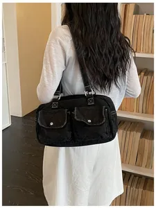 Back view of a model wearing a black denim Boston bag with large capacity pockets