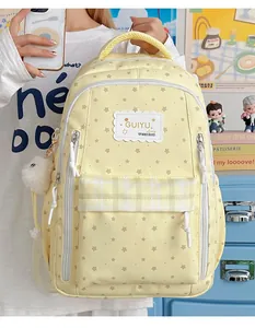 Cute yellow school backpack featuring star patterns and a fluffy white keychain.