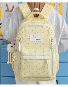 Detailed back view of a yellow star-patterned student backpack with plush keychain charm