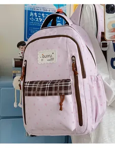 Detailed shot of pink star-patterned student backpack featuring brown plaid pocket detail