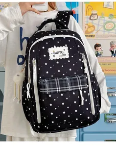 Detail of stylish black star-patterned backpack with white zippers and plaid pocket