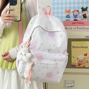Nahaufnahme eines weißen Rucksacks mit Sternenmuster und süßem Plüschanhänger für Mädchen