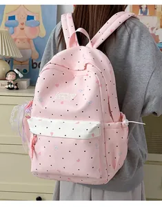 Pink Japanese style cute girl backpack with heart and polka dot patterns for school.