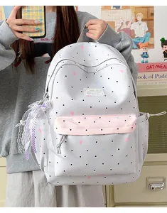 Detail of kawaii Japanese style polka dot backpack with a delicate lace bow charm
